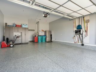 Custom Garage Storage and Organization – Casa Grande AZ Spacious Casa Grande garage with a newly installed overhead door, organized storage cabinets, wall-mounted tools, and a clean epoxy floor.