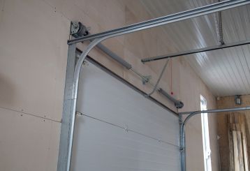 Close-up of new garage door tracks and torsion spring installed in a Casa Grande home garage.