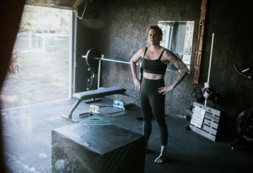 Woman exercising inside a private garage gym conversion in Casa Grande with workout equipment.