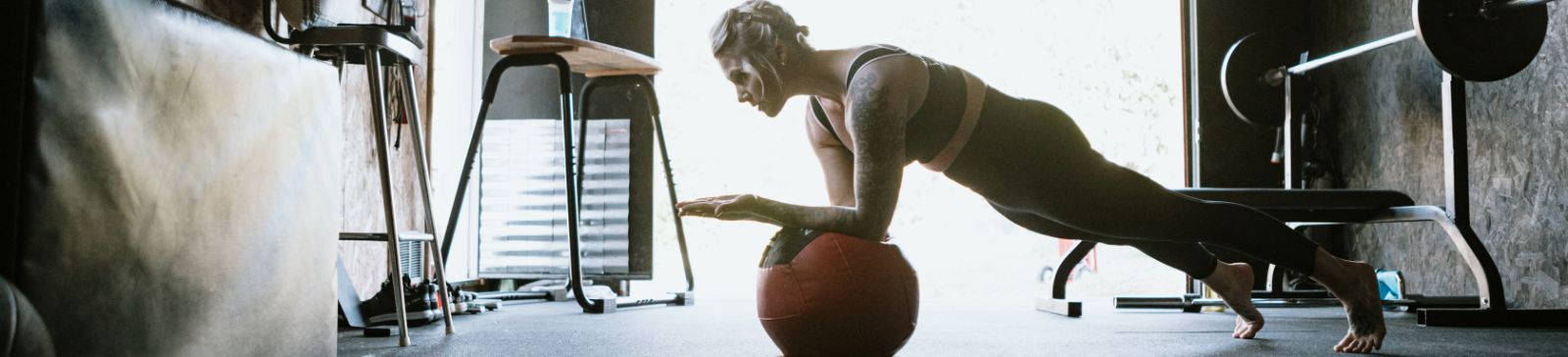 Woman exercising inside a private garage gym conversion in Casa Grande with workout equipment.