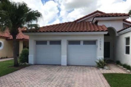Side angle of the Eloy home’s new garage door, showing the fresh installation, white trim, and surrounding landscaping.