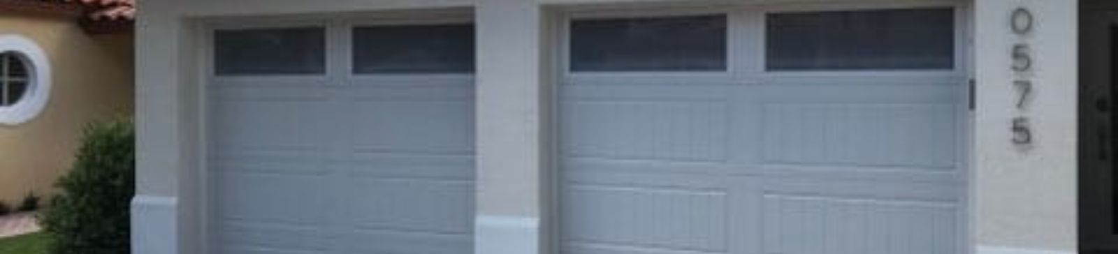 Close-up of the newly installed double garage door in Eloy, highlighting the panel design and frosted upper windows.