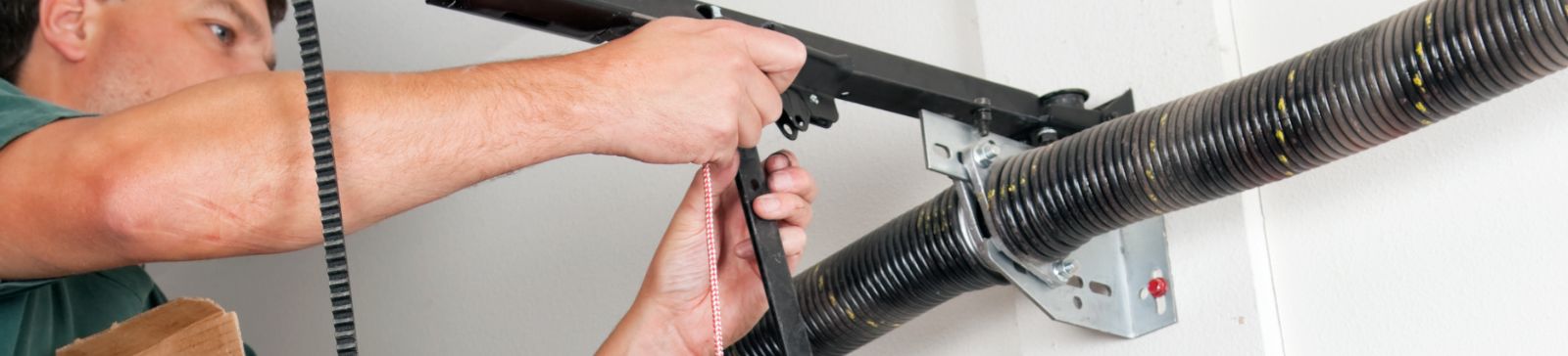 Technician installing a new torsion spring on a residential garage door in Casa Grande, ensuring proper alignment and tension.